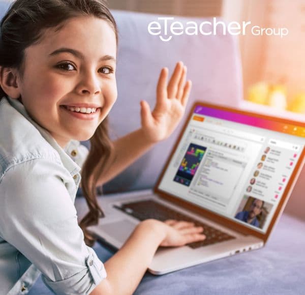 A girl waving at her laptop during an online eTeacher Group lesson.