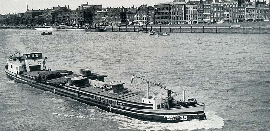 A loaded Rhine barge under way past the Basel waterfront.