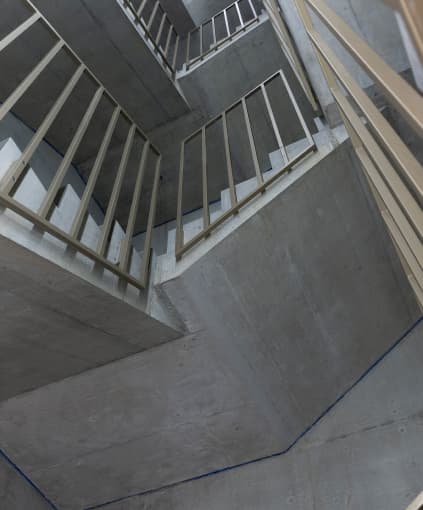 Looking up through the stairwell of a modern concrete building.